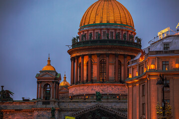 Obraz premium St. Isaac's Cathedral and the Astoria Hotel on a winter evening. The sign on the building in Russian reads 