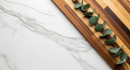 Naklejka premium Eucalyptus branch on wooden cutting board with marble background, top view, copy space