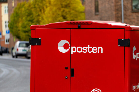 Oslo, Norway - November 03, 2025: Red Posten Delivery Vehicle in Urban Oslo Street Scene