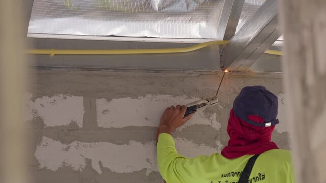 Skilled male welder joining steel beams with electric arc welding. Bright sparks flying in industrial site, heavy construction and metal engineering concept.