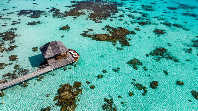 Aerial view of overwater bungalow and sundeck in Fakarava lagoon