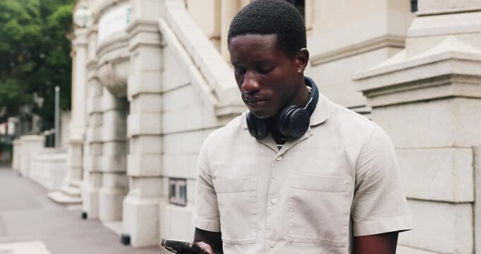 Waiting, headphones or businessman with phone on city street, lift request or transport app for travel. Patience, commute service or black person with tech to track arrival, typing or search for ride