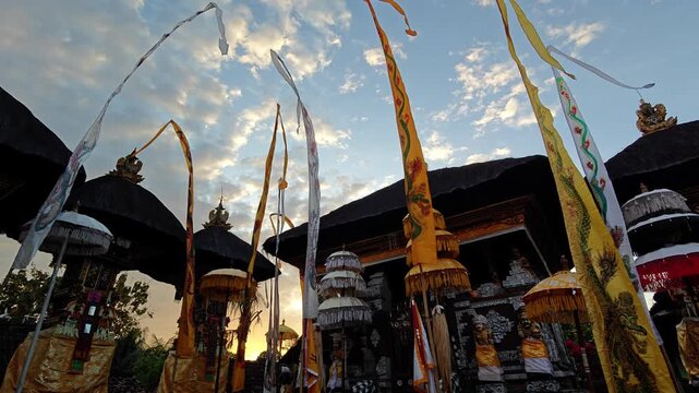 Traditional Balinese Hindu Temple Sanggah Merajan with Ceremonial Ornaments and Penjor at Sunset
