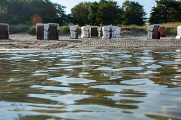 Water with a view of blurred beach chairs in the background
