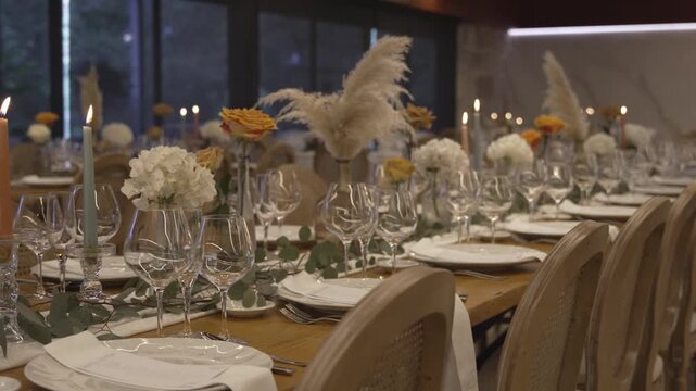 Wedding table setup with plates candles flowers and glasses indoors