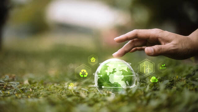 Digital ESG and Sustainable Technology Concept with Hand Touching Green Globe Interface