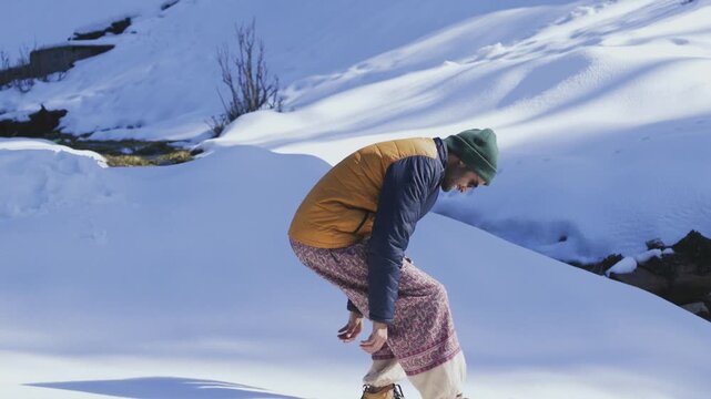 Man Making Snow Angel with Snowshoes on Snowy Field in Manali, Himachal Pradesh, India &ndash; 4K
