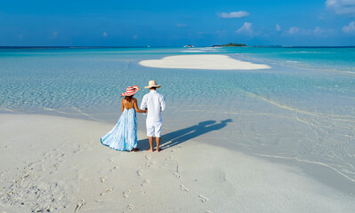 Happy vacation with summer and romantic of couple in a Paradise white sand beach lagoon at Maldives
