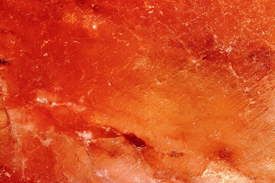 Himalayan salt block texture with mineral crystals and natural abstract stone pattern. Concept of wellness therapy, spa atmosphere, and luxury natural background design, yellow orange vibrant colors.