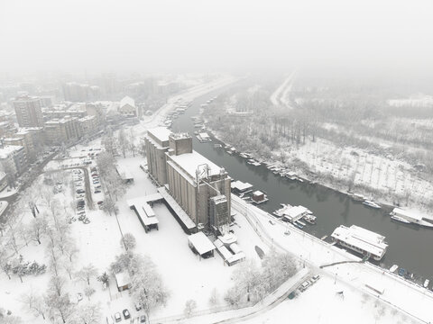 Pancevo, Serbia - January 05 2026: Tamis river in the winter. River in the winter with snow. Boats, bridge. Aerial view. Drone shot.