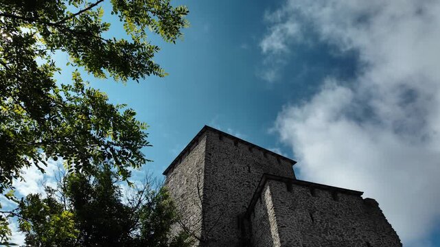 Vrsac Castle tower rising above green hillside under blue sky. Medieval stone fortress landmark overlooking the town in Serbia