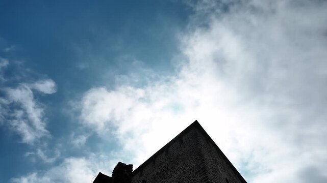 Vrsac Fortress stone tower and walls under blue sky with clouds in Serbia. Medieval stronghold landmark standing on the hill above the town