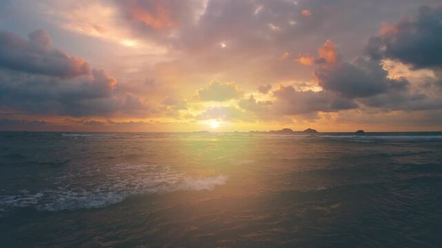 Dramatic sunset over the ocean with colorful clouds and gentle waves, creating a serene and tranquil atmosphere, premium quality 4K animation for creative projects.