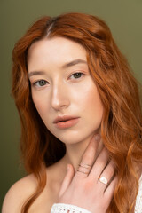 Naklejka premium Redhead woman in stylish spring attire shines in studio setting