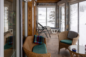 Modern terrace of a mountain lodge looking at the winter scene.