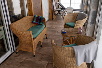 High angle shot of a mountain lodge terrace with wicker furniture.