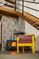 Artisan chair with colorful ornaments by the furnace.