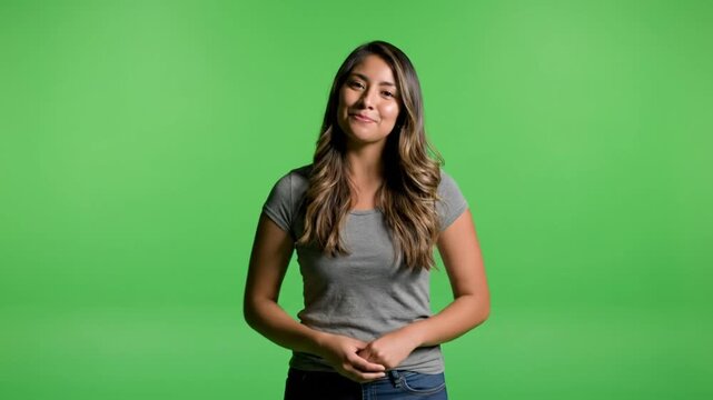 Friendly young woman welcomes viewers with open arms on a green screen backdrop for video content