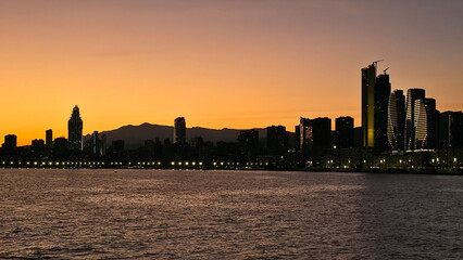 City skyline creating a silhouette against orange sunset sky © Chebix