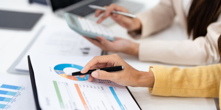 Two colleagues engaged in business analytics,  over financial charts. Colleagues Collaborating on Business Analytics.