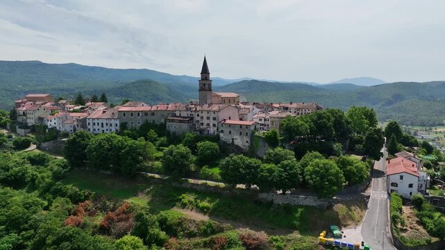 aerial drone view of Buzet historic medieval town in Istria Croatia at early summer showing old stone buildings, hilltop settlement, surrounding forests and green valley landscape