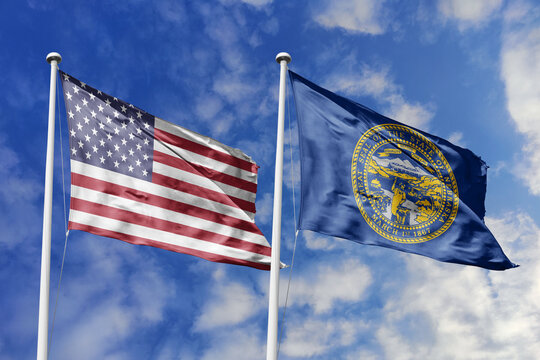 United States and Nebraska State Flags Waving in Unison Against a Blue Sky Symbolizing Federal Unity Midwestern Agricultural Heritage Pioneers and the Industrious Spirit of the Cornhusker State