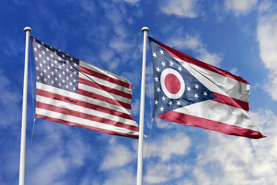 United States and Ohio State Flags Waving in Unison Against a Blue Sky Symbolizing Federal Unity Midwestern Industrial Strength and the Unique Burgee Spirit of the Historic Buckeye