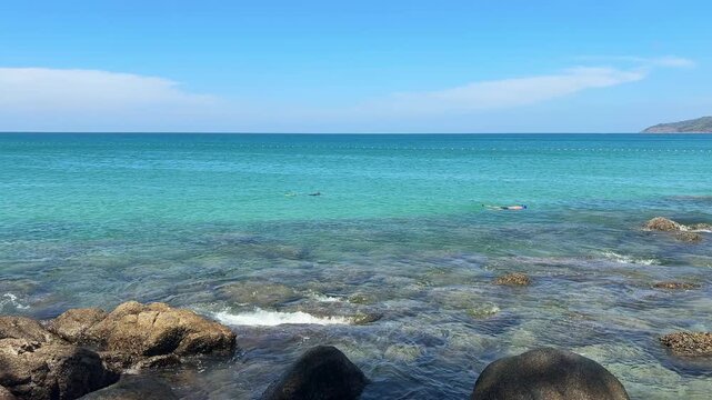 Two People Snorkeling in Clear Turquoise Water at Karon Beach, Phuket Thailand