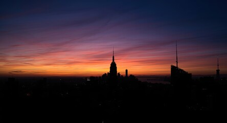 Naklejka premium Silhouetted skyscrapers against a colorful evening sky