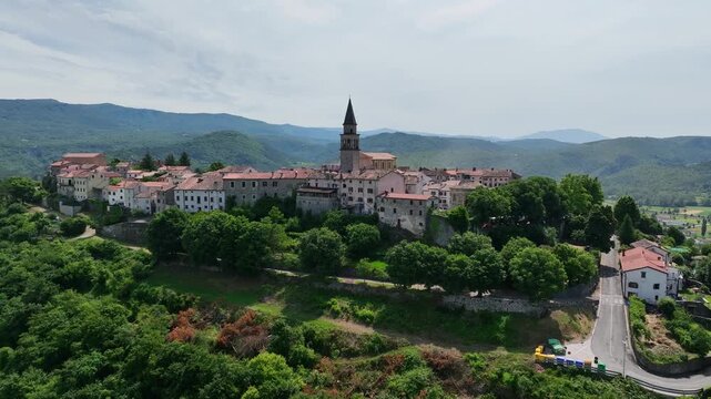 erial drone view of Buzet historic medieval town in Istria Croatia at early summer showing old stone buildings, hilltop settlement, surrounding forests and green valley landscape