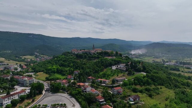 erial drone view of Buzet historic medieval town in Istria Croatia at early summer showing old stone buildings, hilltop settlement, surrounding forests and green valley landscape