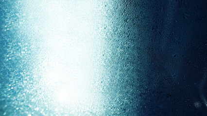 Obraz premium Sunlit Glass Surface with Shimmering Water Droplets and Bokeh