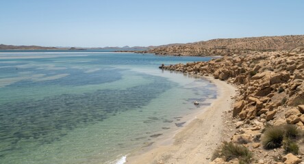 Clean salty water expanse bordered by rugged and barren natural terrain