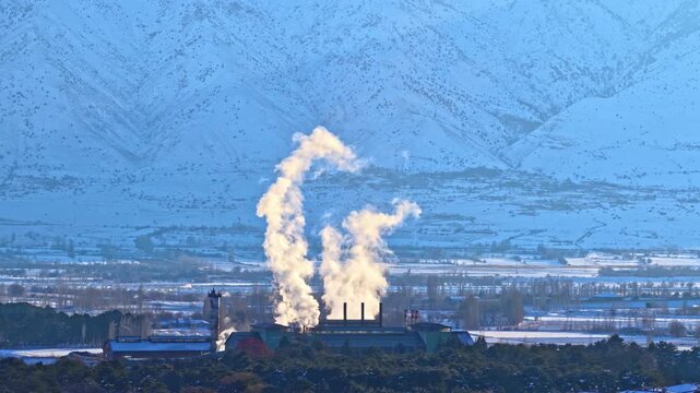 Winter Industrial Scene with Sugar Factory and Snow-Covered Mountains
