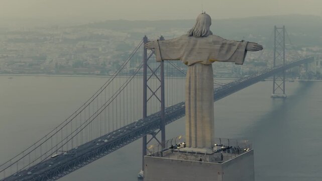 Christ the King statue and 25 de Abril Bridge over Tagus River in Lisbon, Portugal, Drone shoot