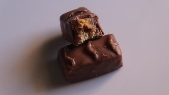 Close-up of two milk chocolate bars with caramel and nougat filling