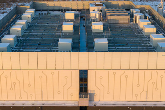 Modern data center infrastructure featuring a facade with circuit board patterns and rooftop hvac cooling units, Warszawa, Wojewodztwo mazowieckie, Poland.