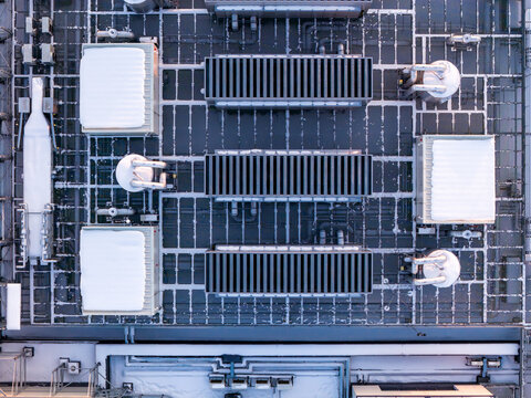 Rooftop of a modern data center with various hvac and cooling units covered in light snow, ensuring optimal server performance, Warszawa, Wojewodztwo mazowieckie, Poland.