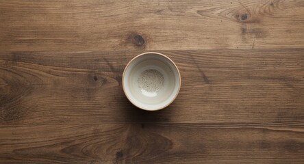 Top viewpoint of simple bowl positioned on natural hardwood backdrop featuring copy space