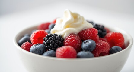 A nutritious bowl of mixed berries with cream captured closely for breakfast lunch or dinner