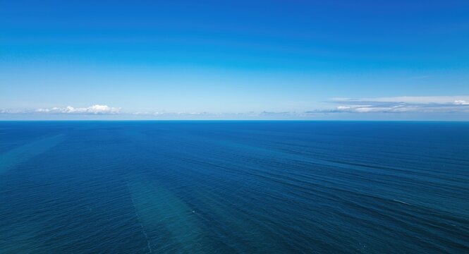 view from above of a vast ocean with moderate waves under clear blue sky