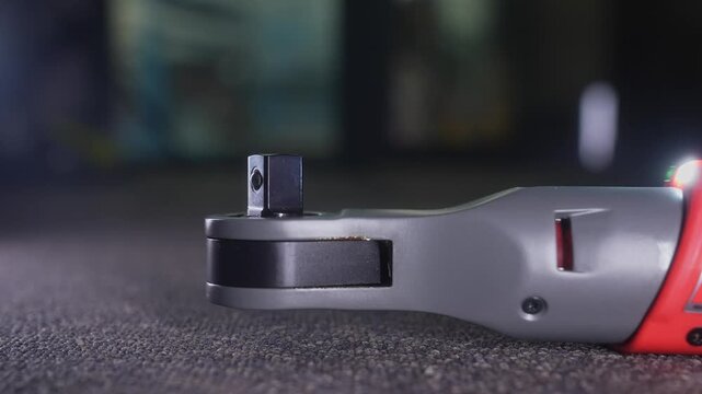 Detailed view of an electric ratchet wrench placed against a soft carpet background, showcasing tool design.