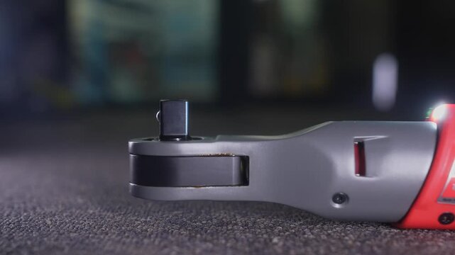 Detailed view of an electric ratchet wrench placed against a soft carpet background, showcasing tool design.