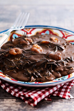 Mexican romeritos with mole sauce and shrimp on wooden table