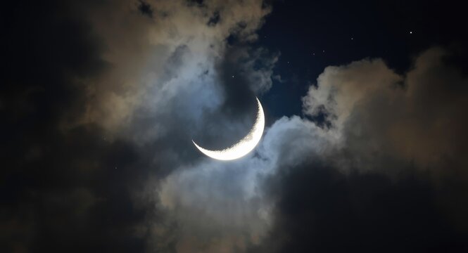 White crescent moon brightened by a softly glowing cloud background