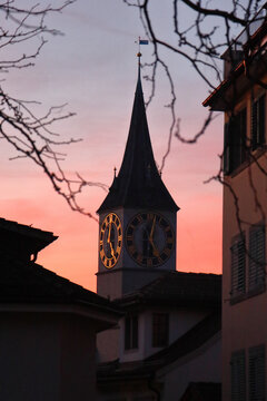 st peter church clock tower illuminated at pink sunset zurich