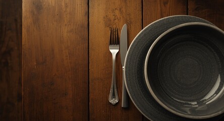 Fototapeta premium Flat lay photo of rustic wooden table setting with knife fork and plate
