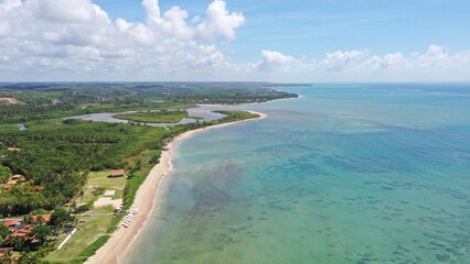 Aerial view of the calm and private beaches of Milagres route with turquoise water, white sand beach, coconut trees and a relaxing landscape. Milagres, Maceio city, Alagoas State, Brazil 