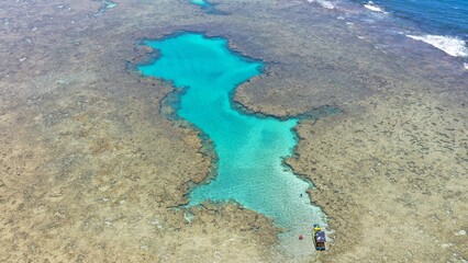 Obraz premium Fantastic aerial view of the turquoise waters of Toque beach with dozen of small boats with tourists on the natural pools formed among coral reefs in Milagres route near Maceio, Alagoas State, Brazil 