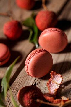 Lychee Macarons on Rustic Wooden Table with Fresh Fruit